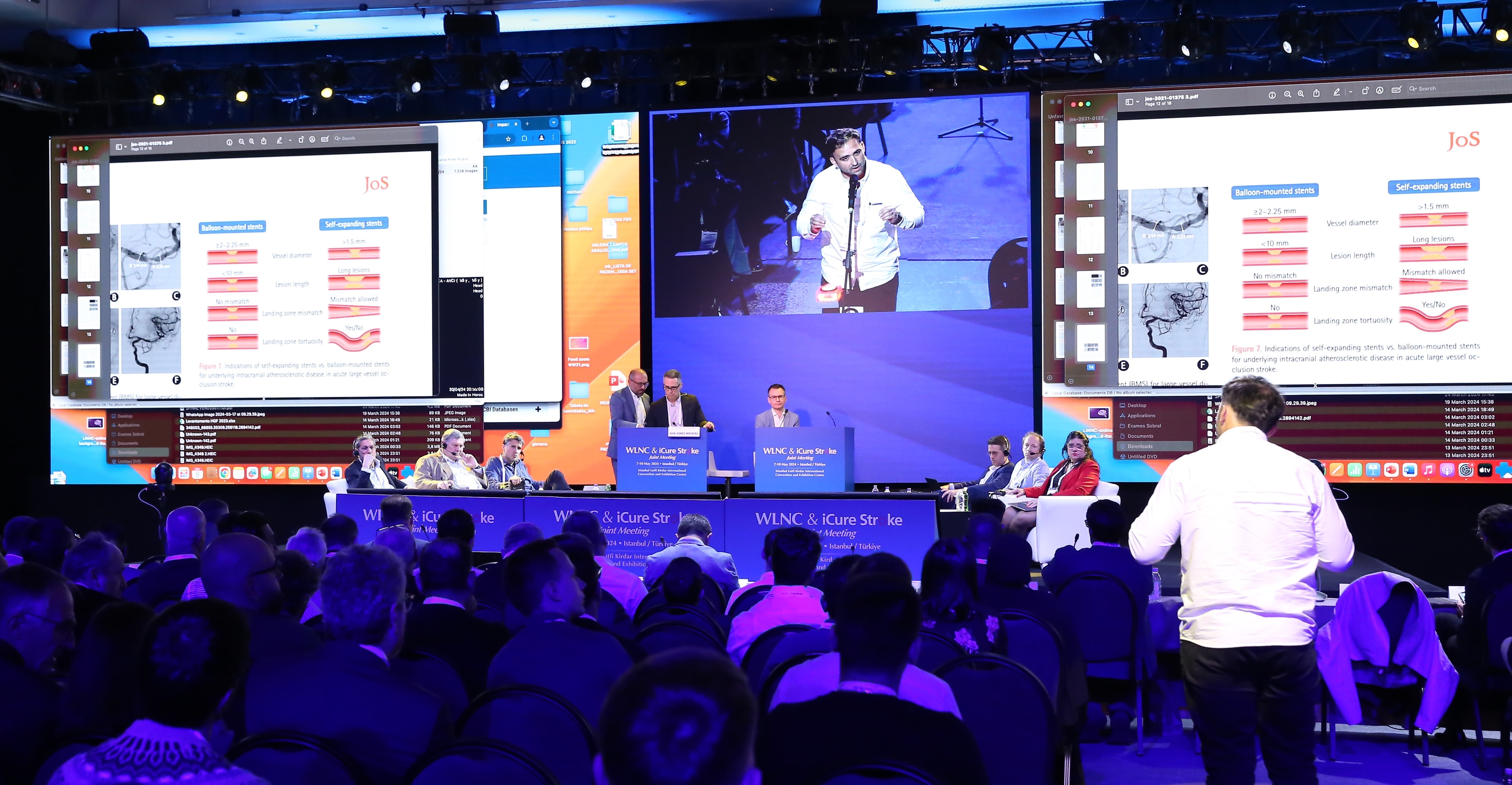 Live session at WLNC 2024 with a participant engaging in discussion via the Spotlight Button, while dual projection screens display neurovascular stent comparison visuals and a live camera feed of the speaker.