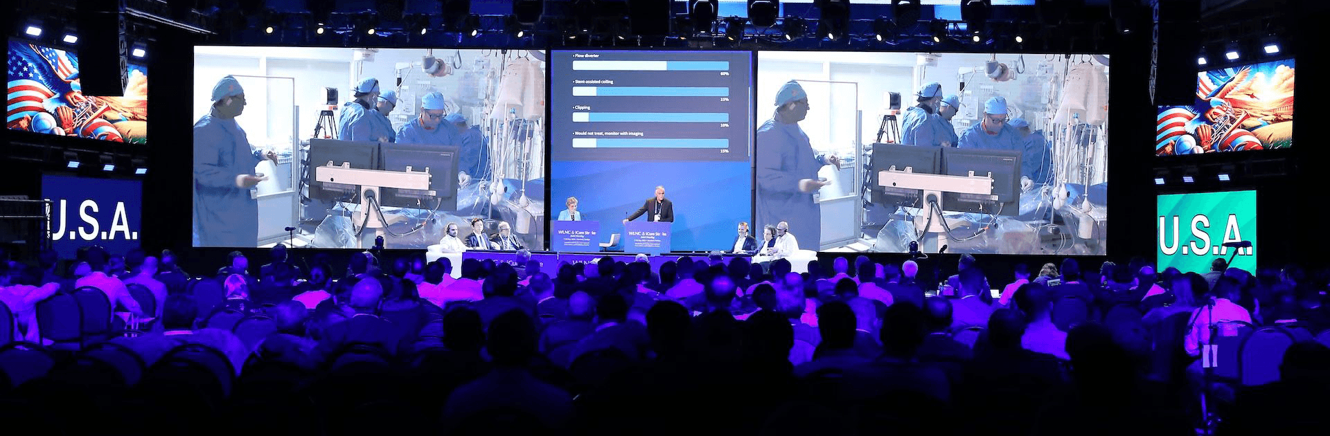 Wide view of WLNC 2024 main stage showing live neurovascular surgery broadcast from the USA, with real-time polling and expert panel discussions engaging a global audience